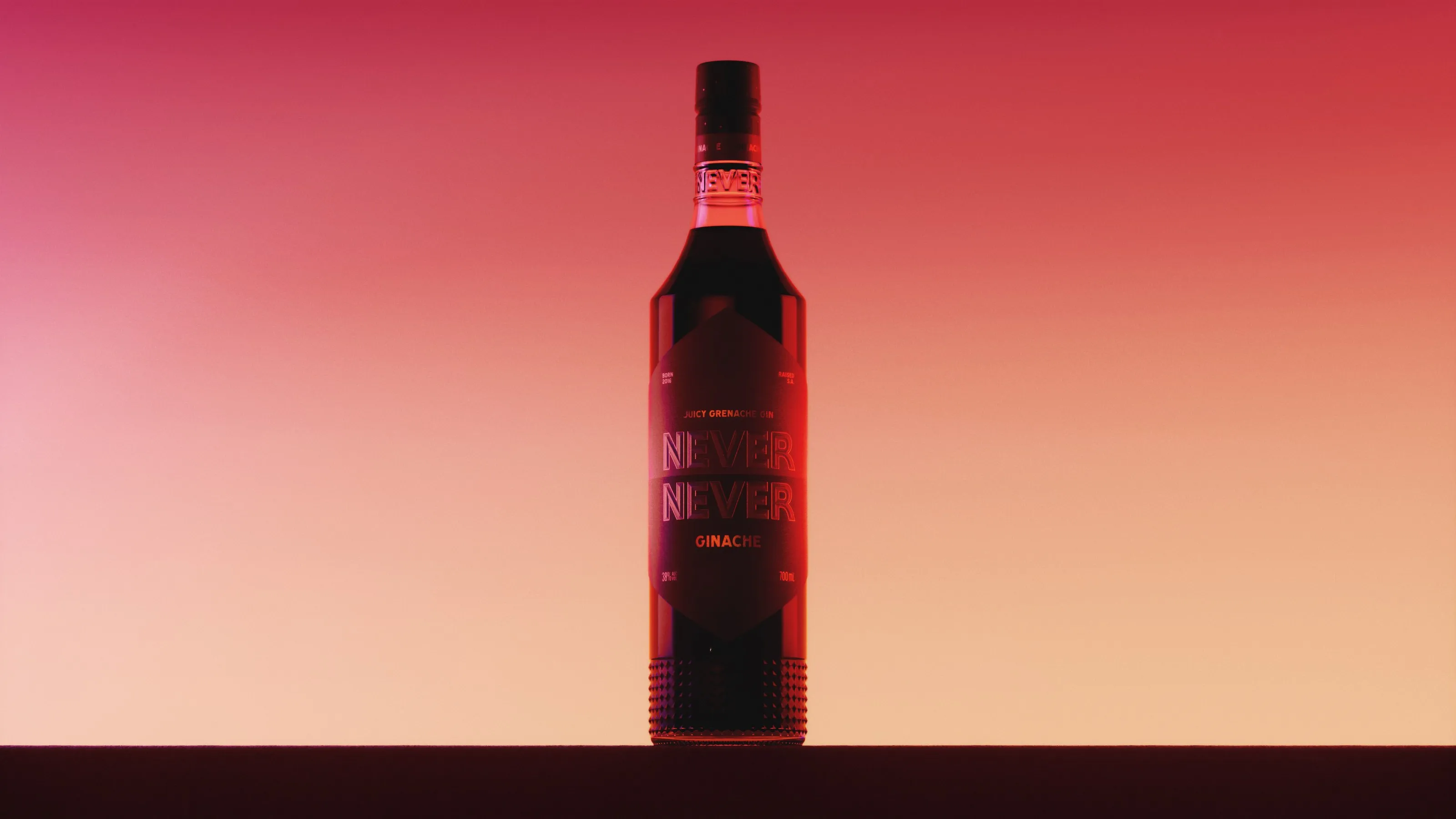 Never Never Ginache bottle backlit against a red and amber horizon