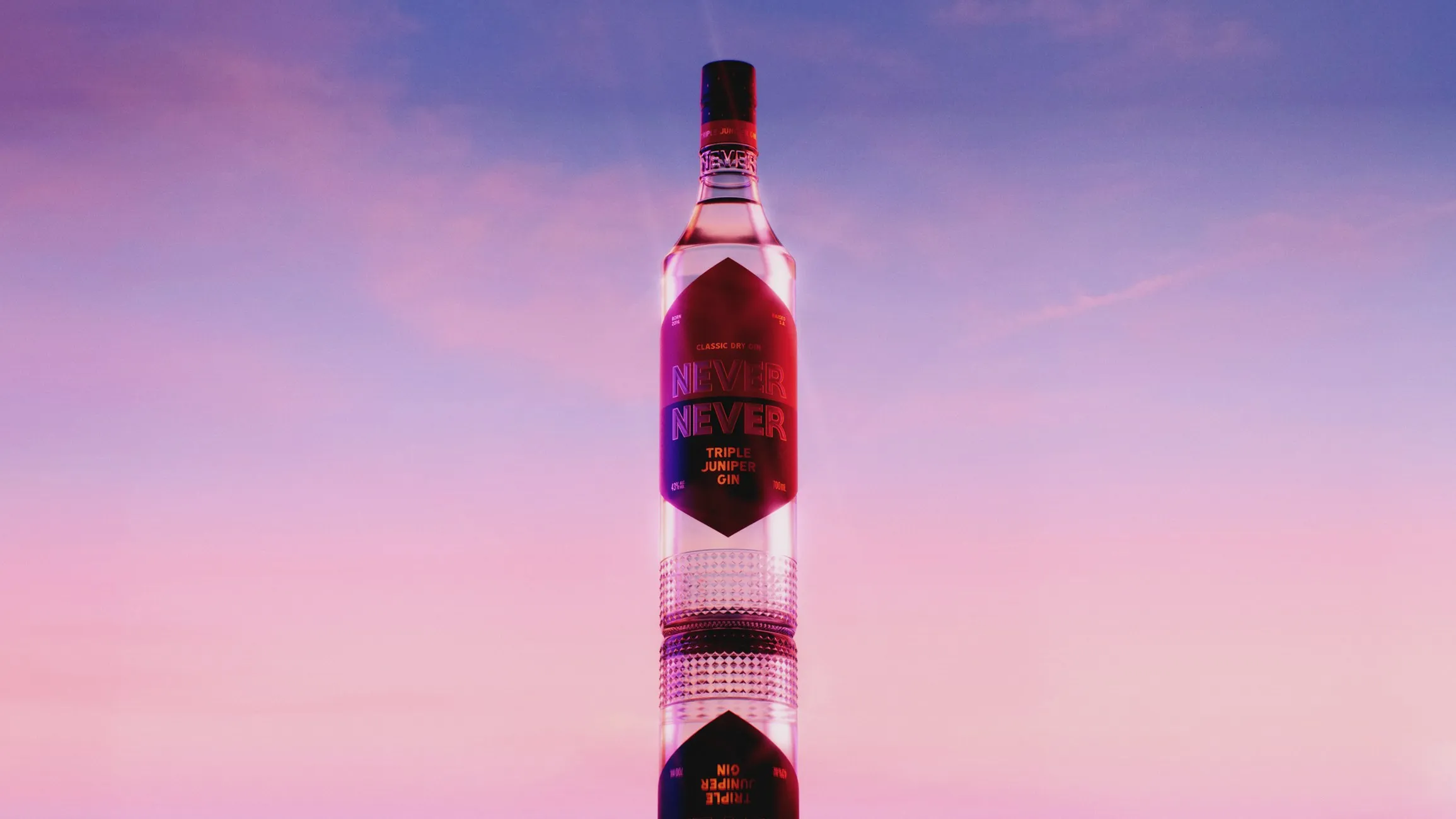Never Never Triple Juniper Gin bottle and its reflection against a pink and violet dusk sky